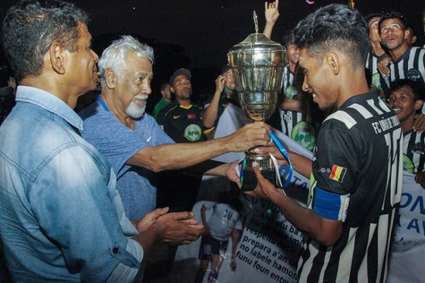 Lider Istoriku, Kay Rala Xanana Gusmão entrega taxa no hasai fotografia hamutuk ho jogador FC Tokodede ne’ebé hetan primeiru lugar iha kompetisaun final jogu Taxa Rotativa Avó Nana Postu Administrativu Lospalos, Munisipiu Lautem. Imajen/ Espesiál.